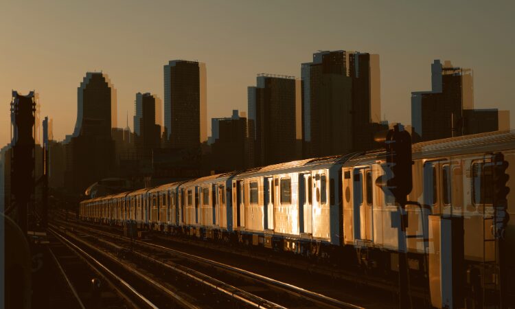 photo of a subway train in front of a skyline
